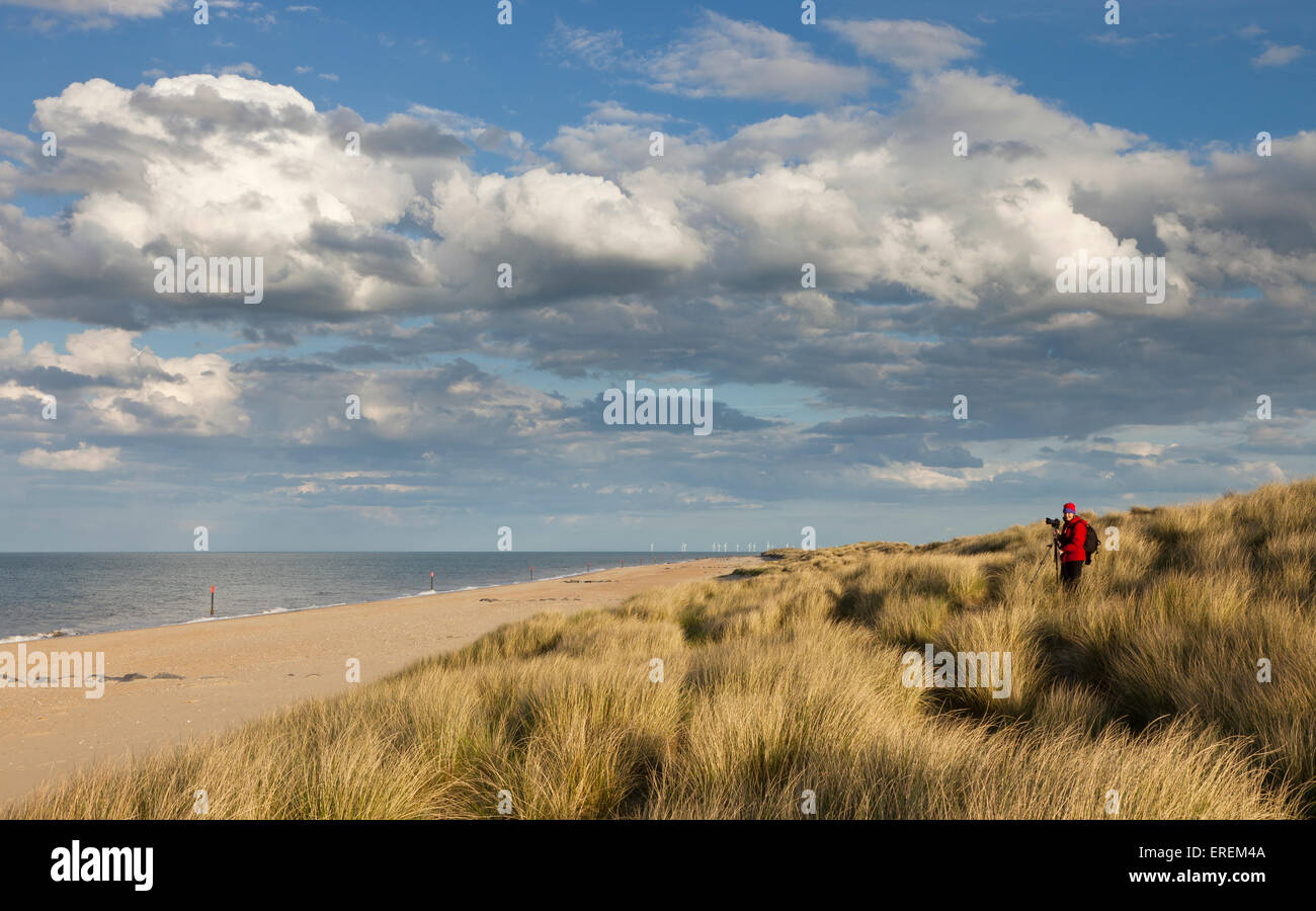 A photographer with her camera and tripod on Horsey beach in north east Norfolk England Stock Photo