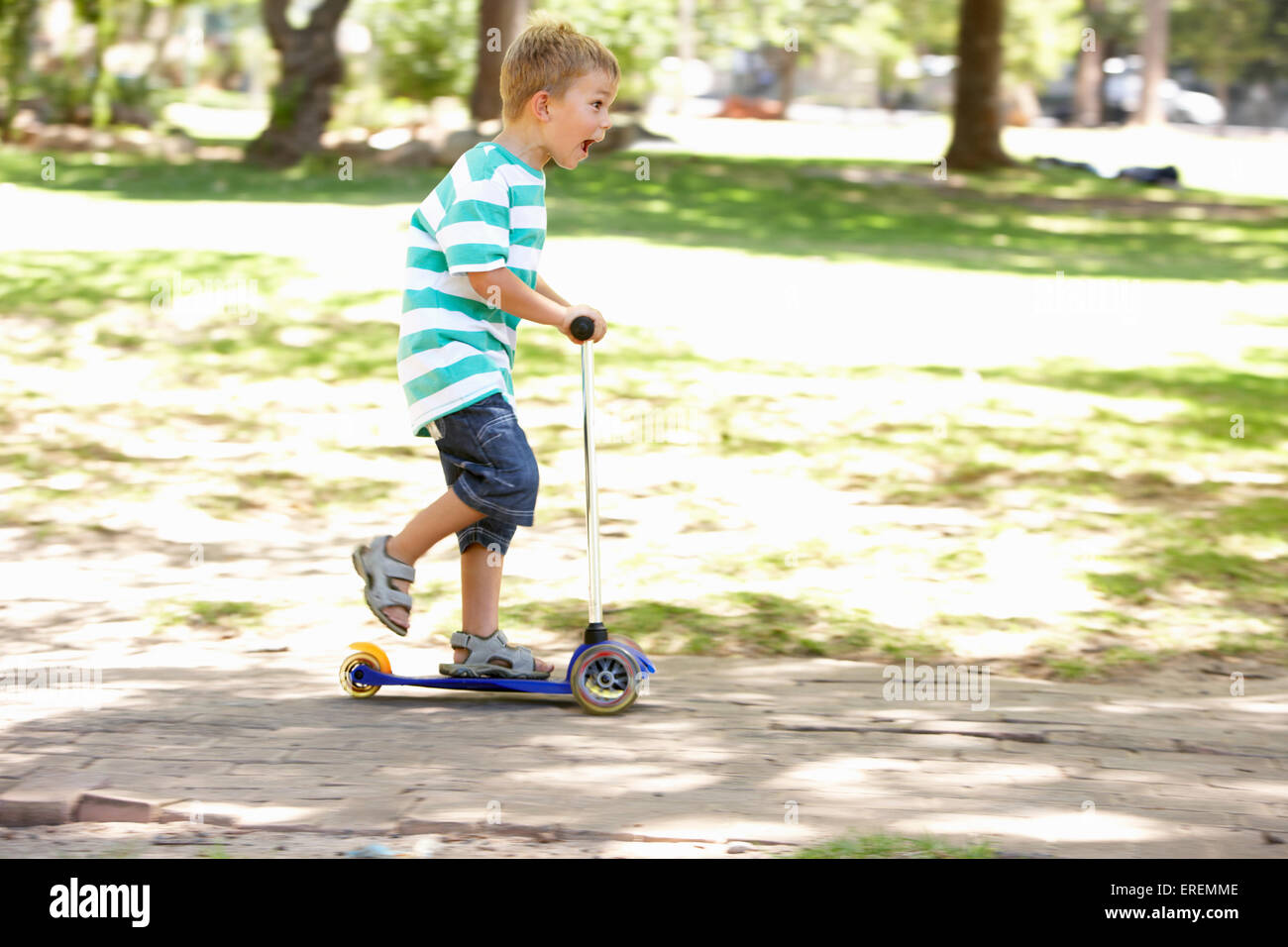 Young Boy On Scooter In Park Stock Photo