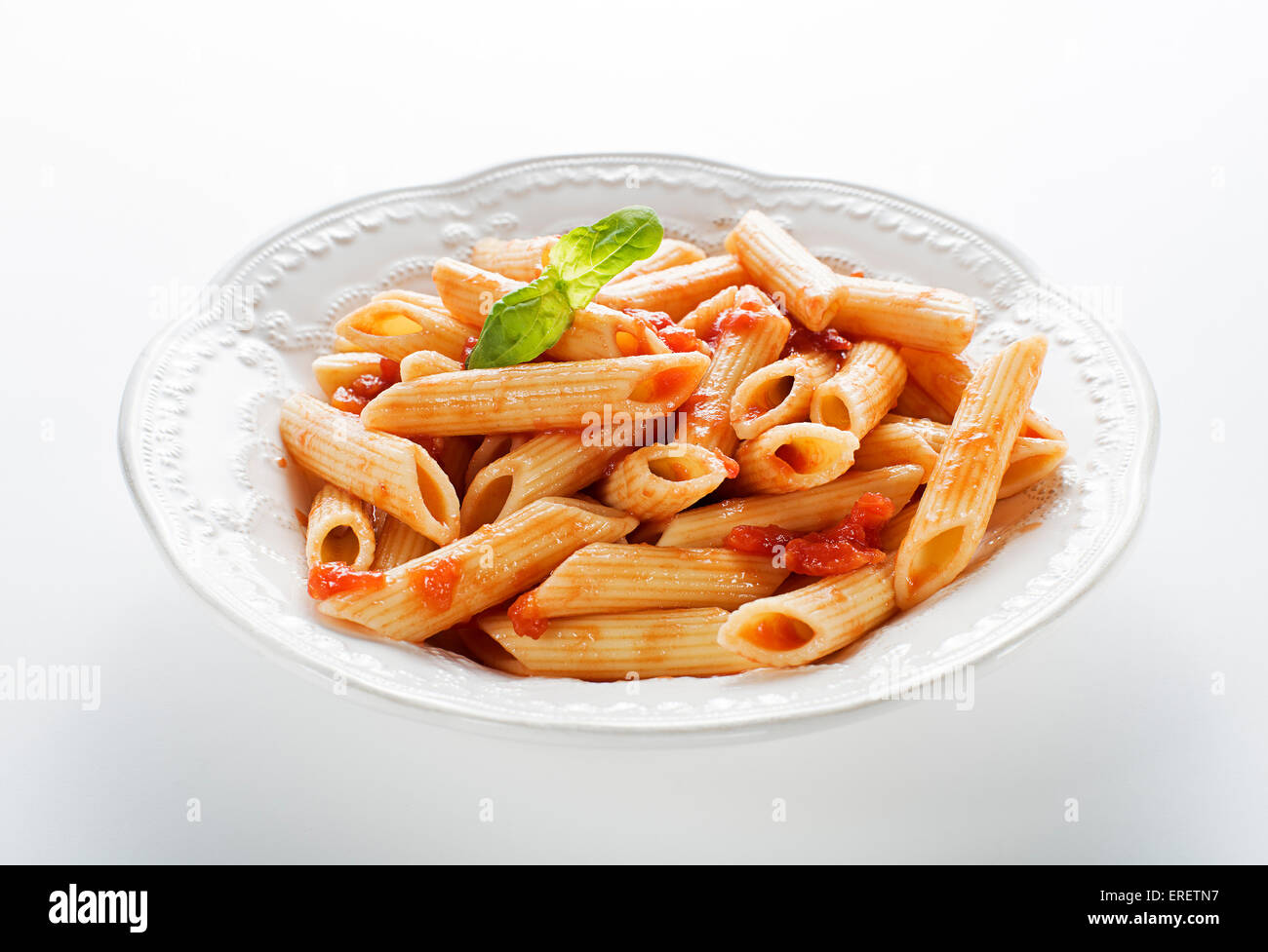 Plate of penne pasta with tomato sauce on white background Stock Photo