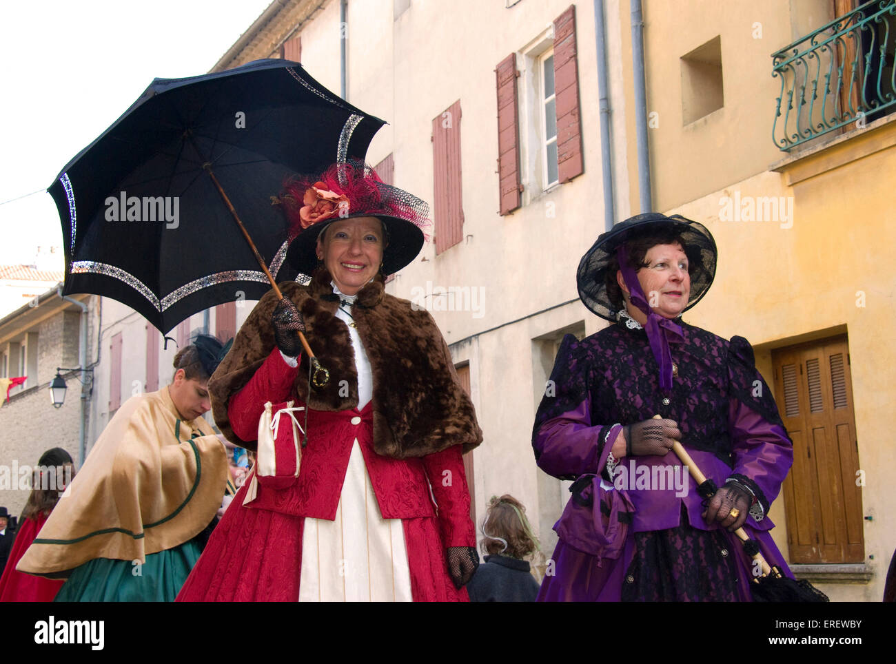 Two ladies in Victorian costumes taking part in a Valentine's Day parade in the village of Roquemaure, Southern France. Stock Photo
