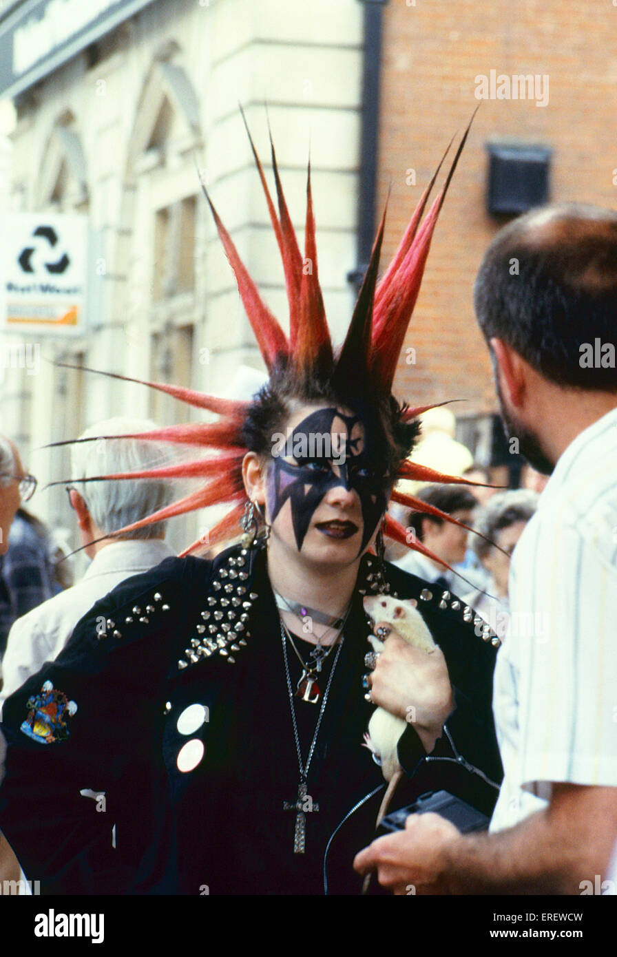 Punk girl with gothic make-up, extravagant hairdo and carrying a pet rat, pictured in the Covent Garden district of London in Stock Photo