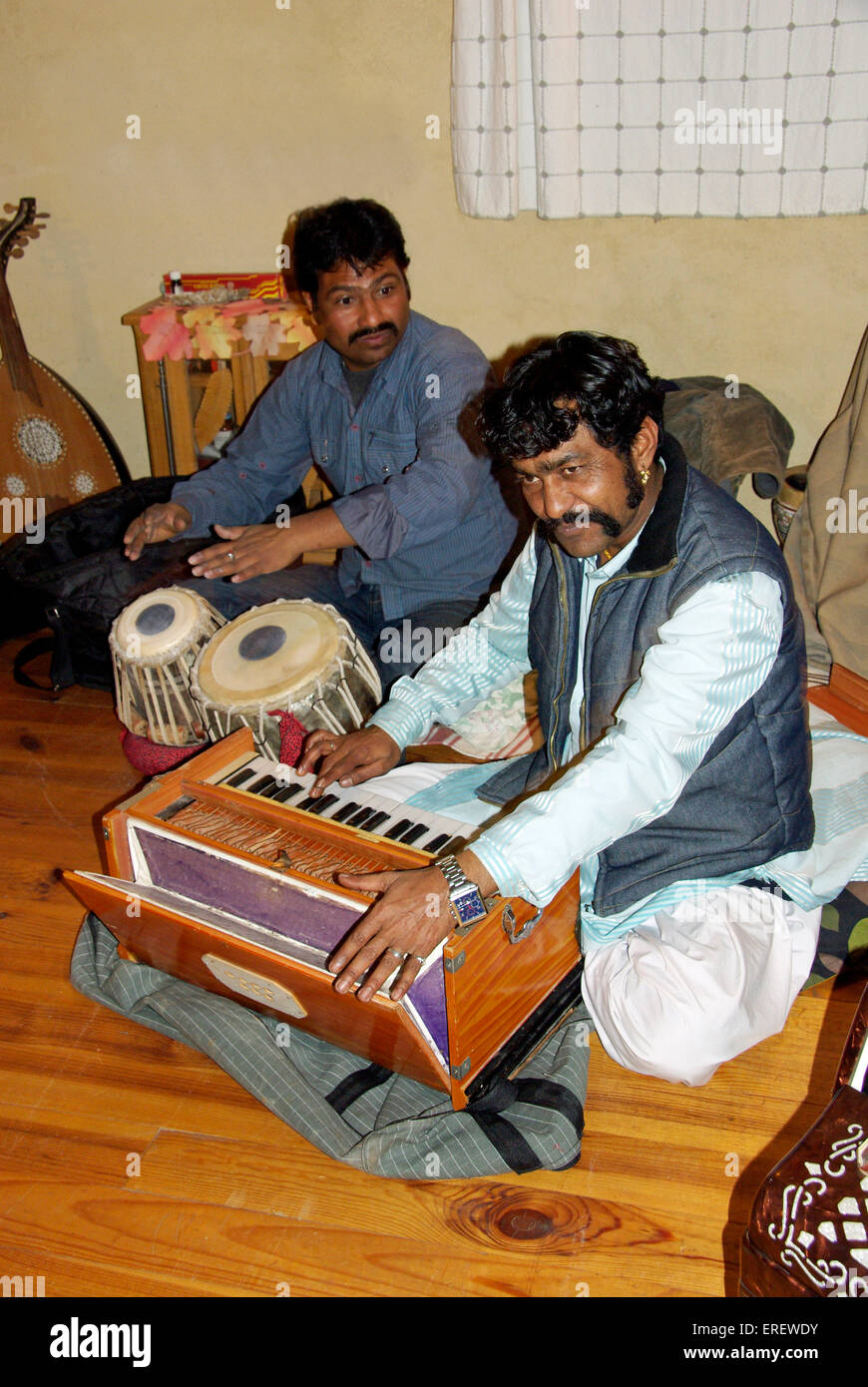 Indian harmonium and tabla players  performing in a private setting. Stock Photo