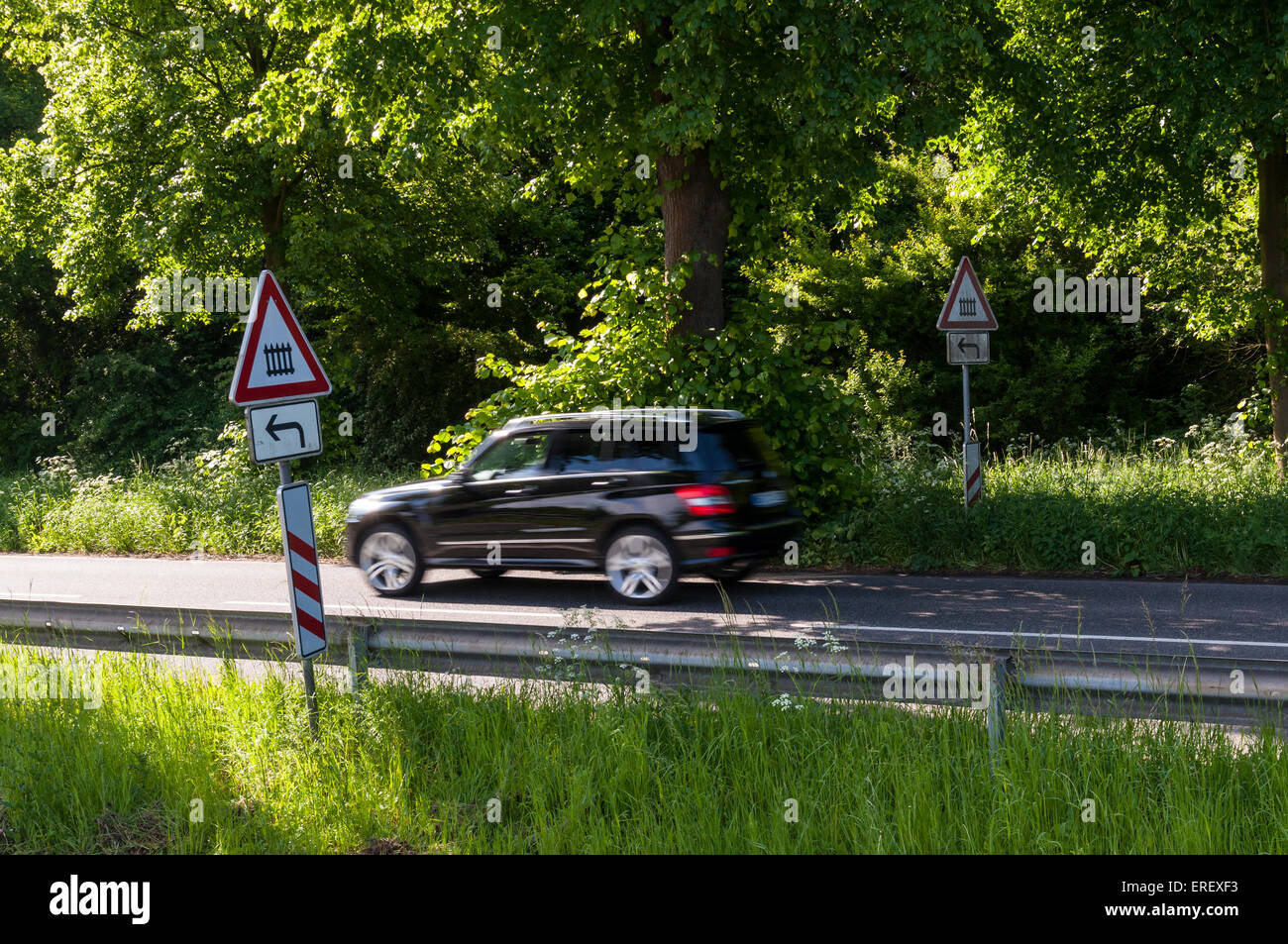 Country Road With Passing Car And Signs For A Gated Level Crossing To The Left Germany Stock Photo Alamy