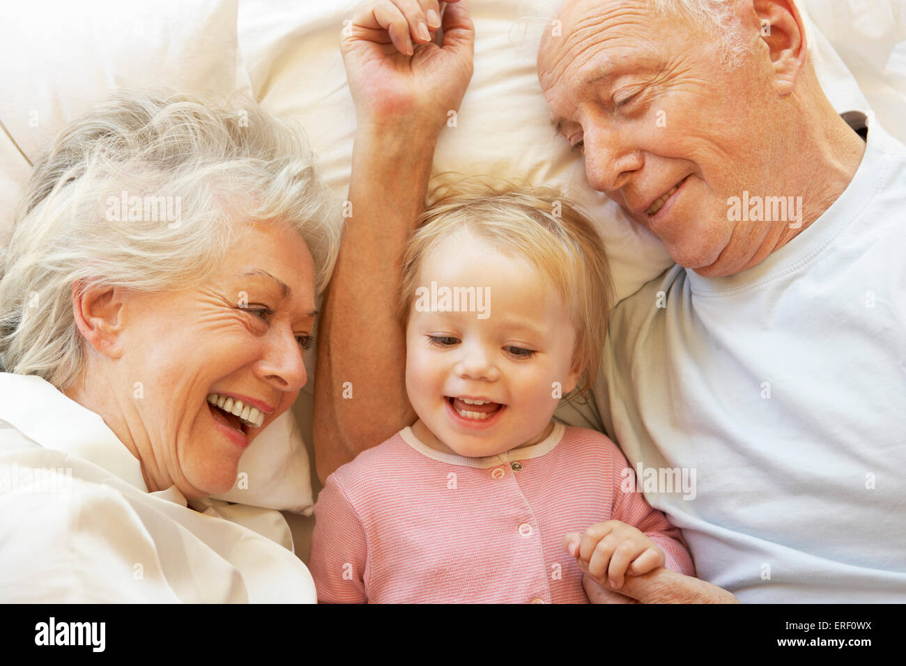 Grandparents grandchild in bed together hires stock photography and