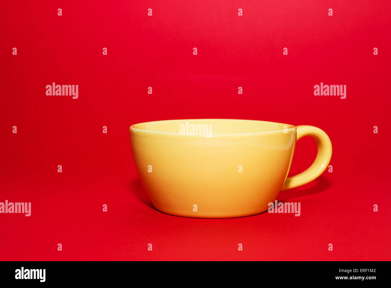 Yellow cup for drinks on a red background Stock Photo Alamy
