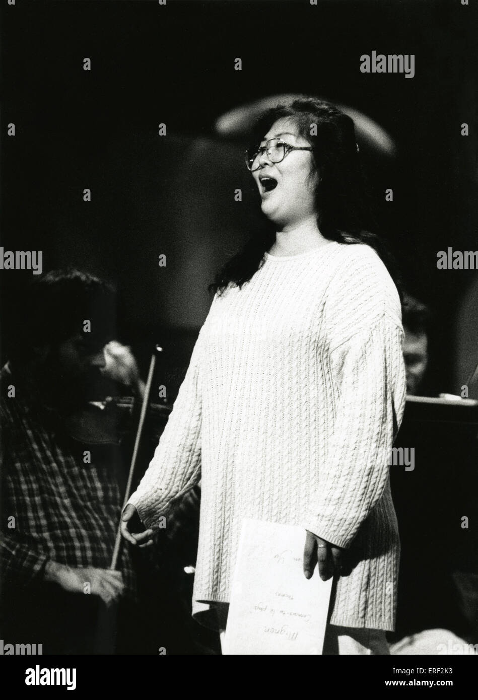 Guang Yang - mezzo-soprano Three-quarter length portrait of Guang Yang singing and holding music Stock Photo