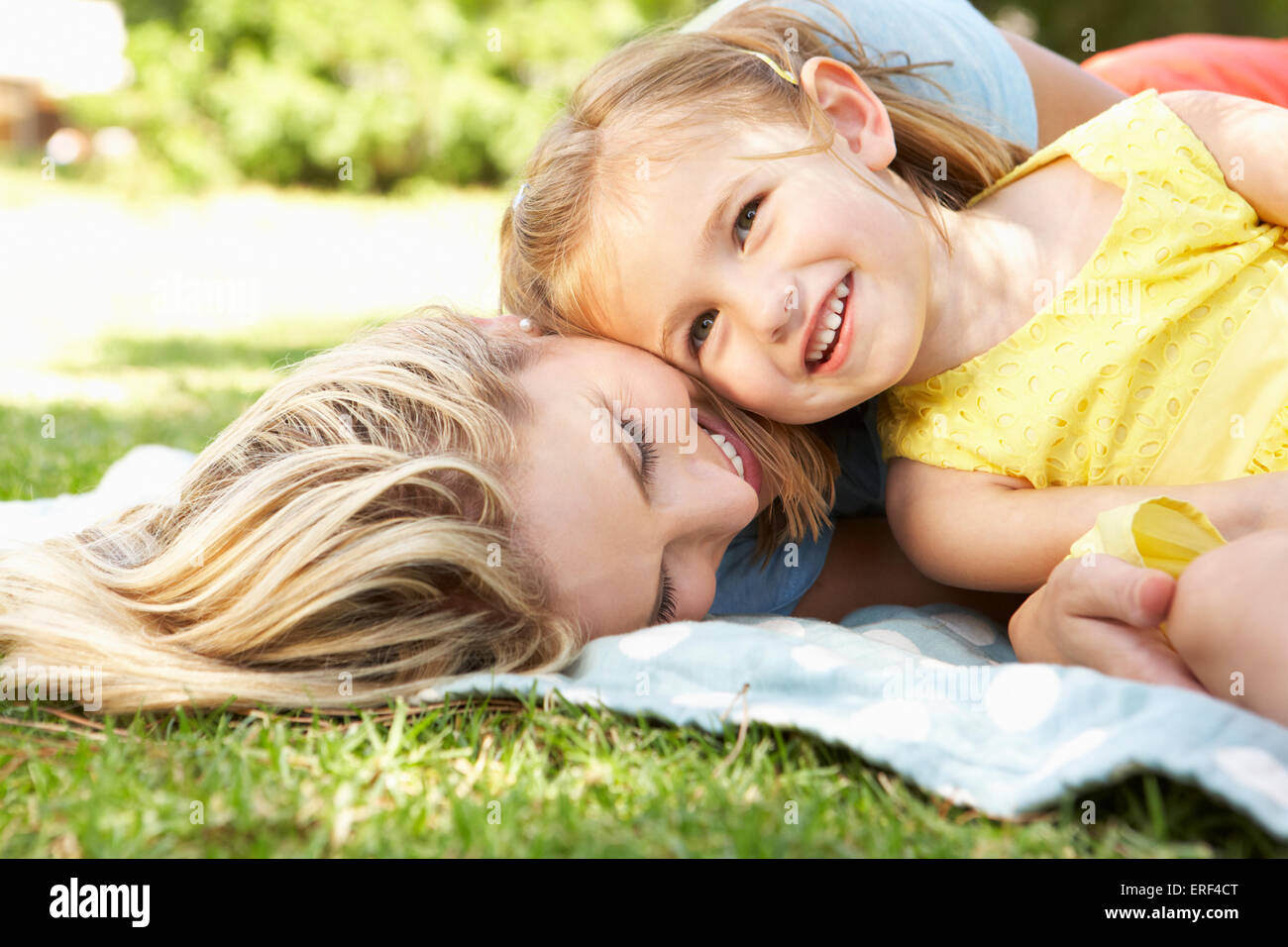 Mother And Daughter Relaxing In Garden Stock Photo