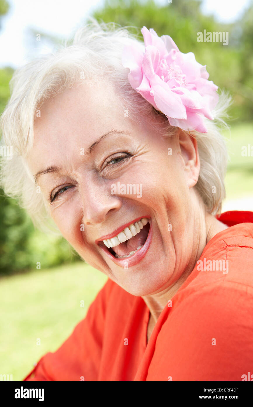 Head And Shoulders Portrait Of Smiling Senior Woman With Flower In Hair ...