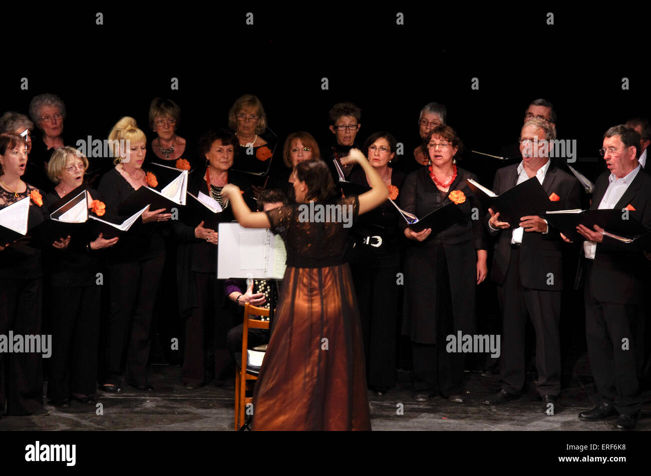 Mixed adult choir with female conductor Stock Photo