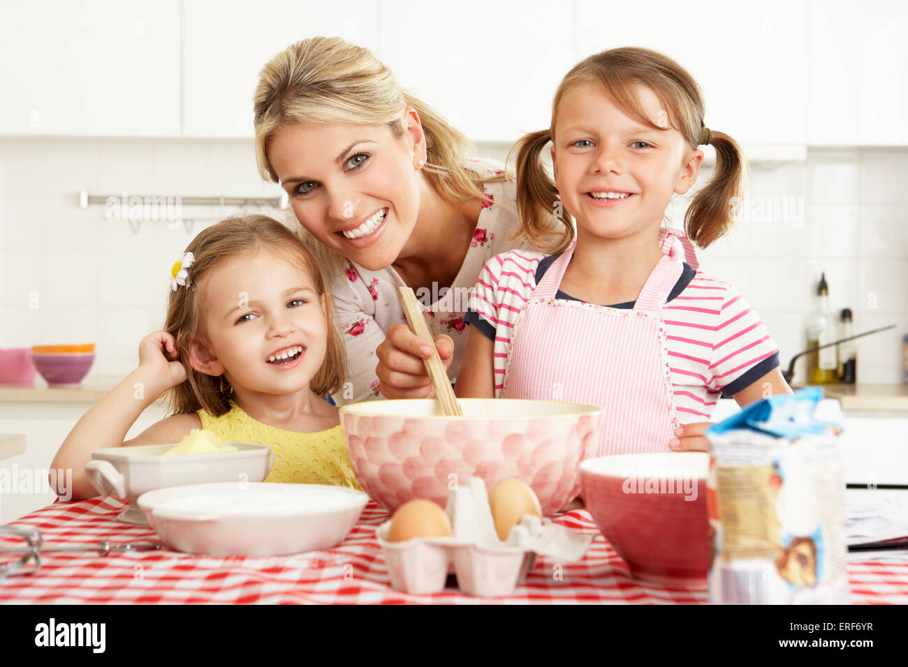 Mother And Two Girls Baking In Kitchen Stock Photo - Alamy