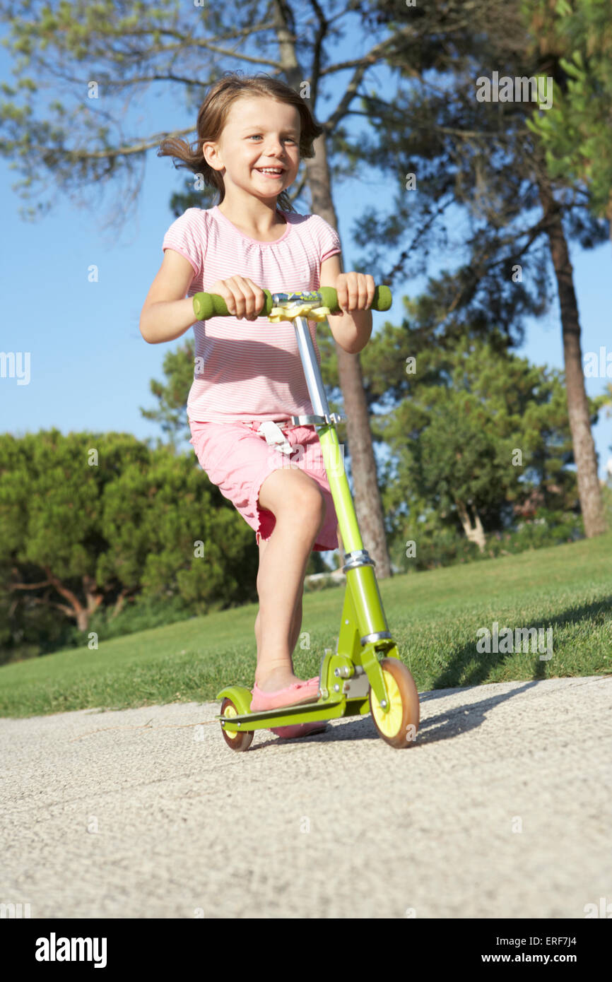 Girl Riding Scooter In Park Stock Photo