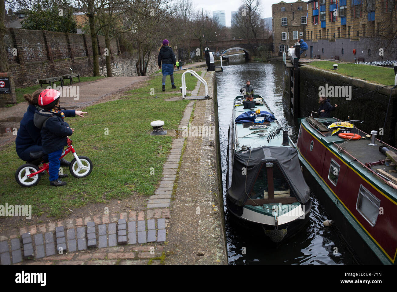 Narrowboat entering a lock on Regents Canal in East London, UK. Regent's Canal crosses an area just north of central London. It provides a link from the Paddington Arm of the Grand Union Canal in the west, to Limehouse and the River Thames in east London. The canal is 13.8 kilometres (8.6 miles) long. Stock Photo