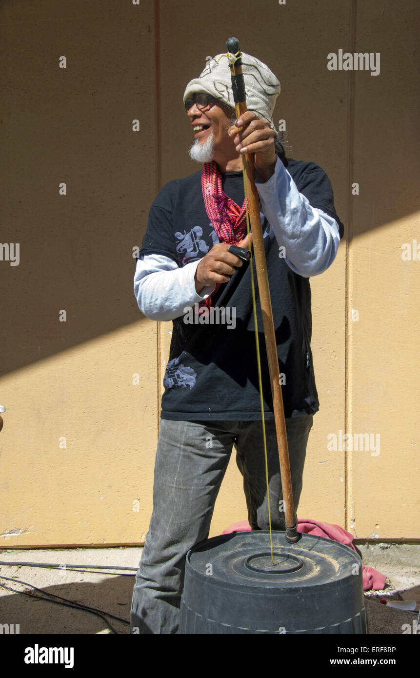 Man playing a washtub bass as part of a fun performance by a band playing  instruments made up of recycled materials Stock Photo - Alamy