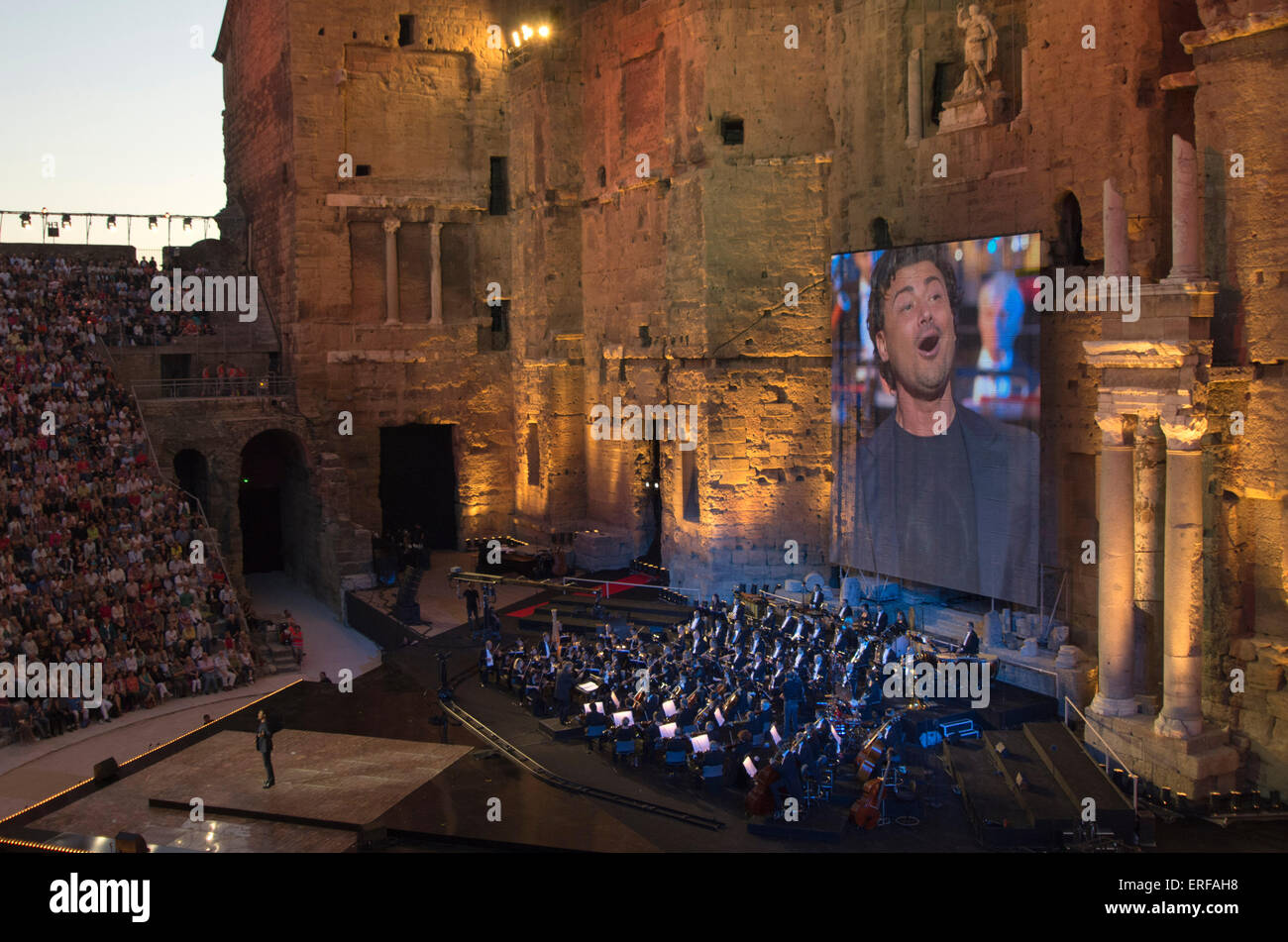 Evening concert on the occasion of National Music Day 2013 in the Roman Theatre of Orange, in France. The singer on the screen Stock Photo