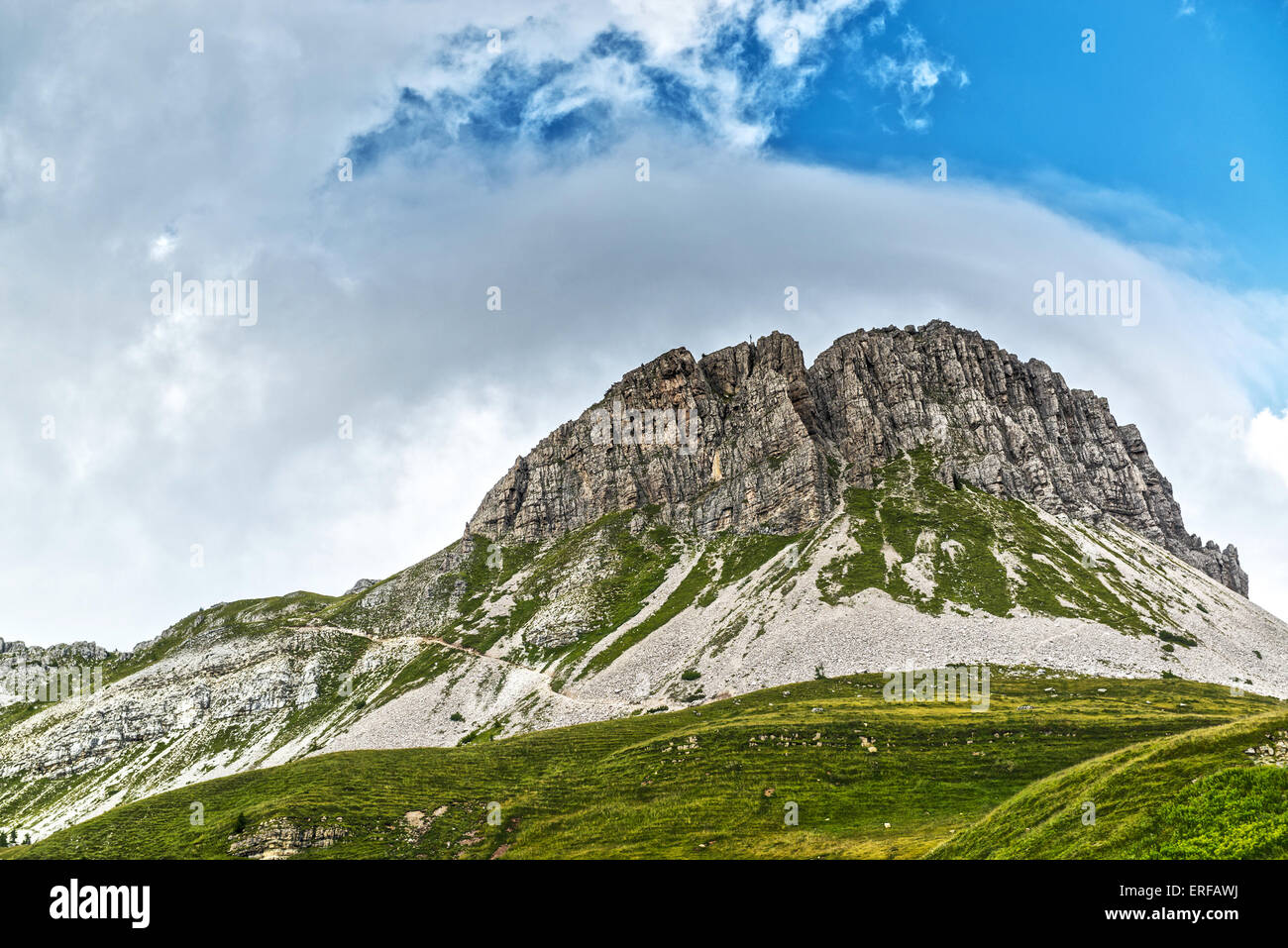 Landscape of the Mountain Castellazzo seen from Rolle Passwith clouds and blue sky background, Dolomites, Trentino - Italy Stock Photo