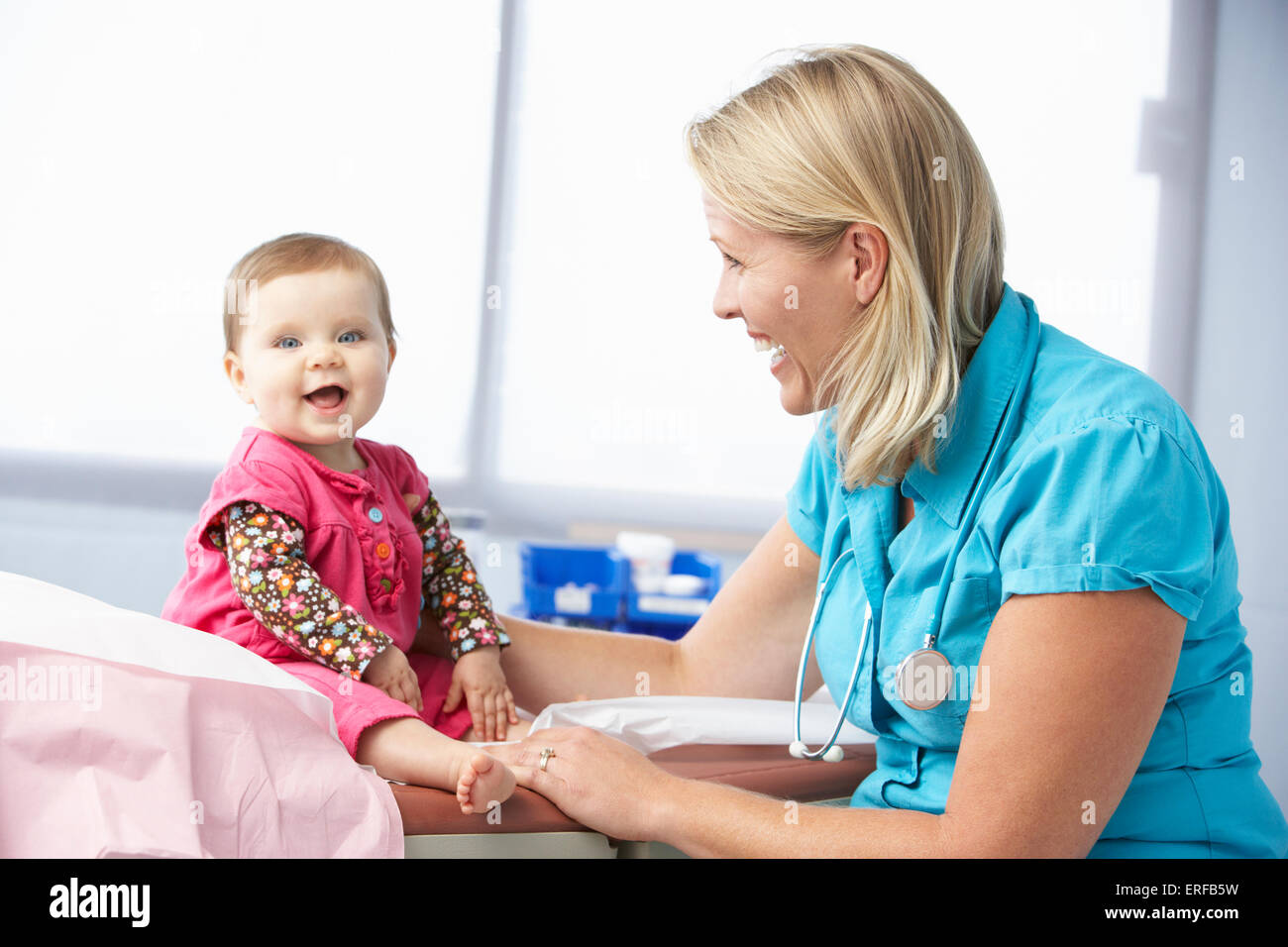 Doctor In Surgery Examining Baby Girl Stock Photo