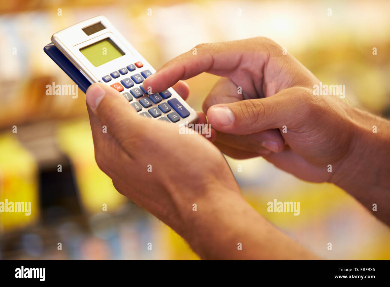 Man In Grocery Aisle Of Supermarket Using Calculator Stock Photo Alamy