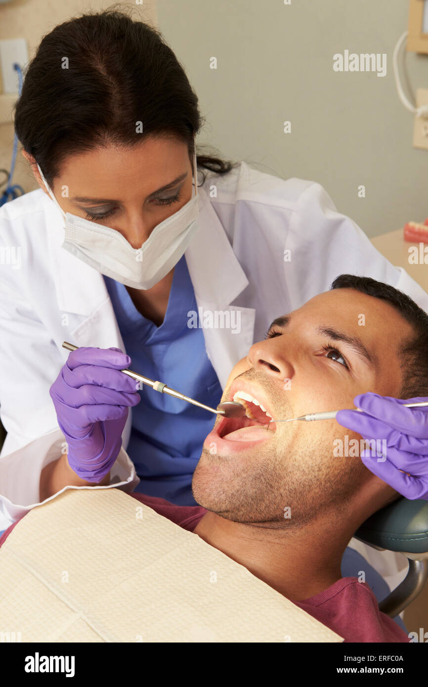 Man Having Check Up At Dentists Surgery Stock Photo