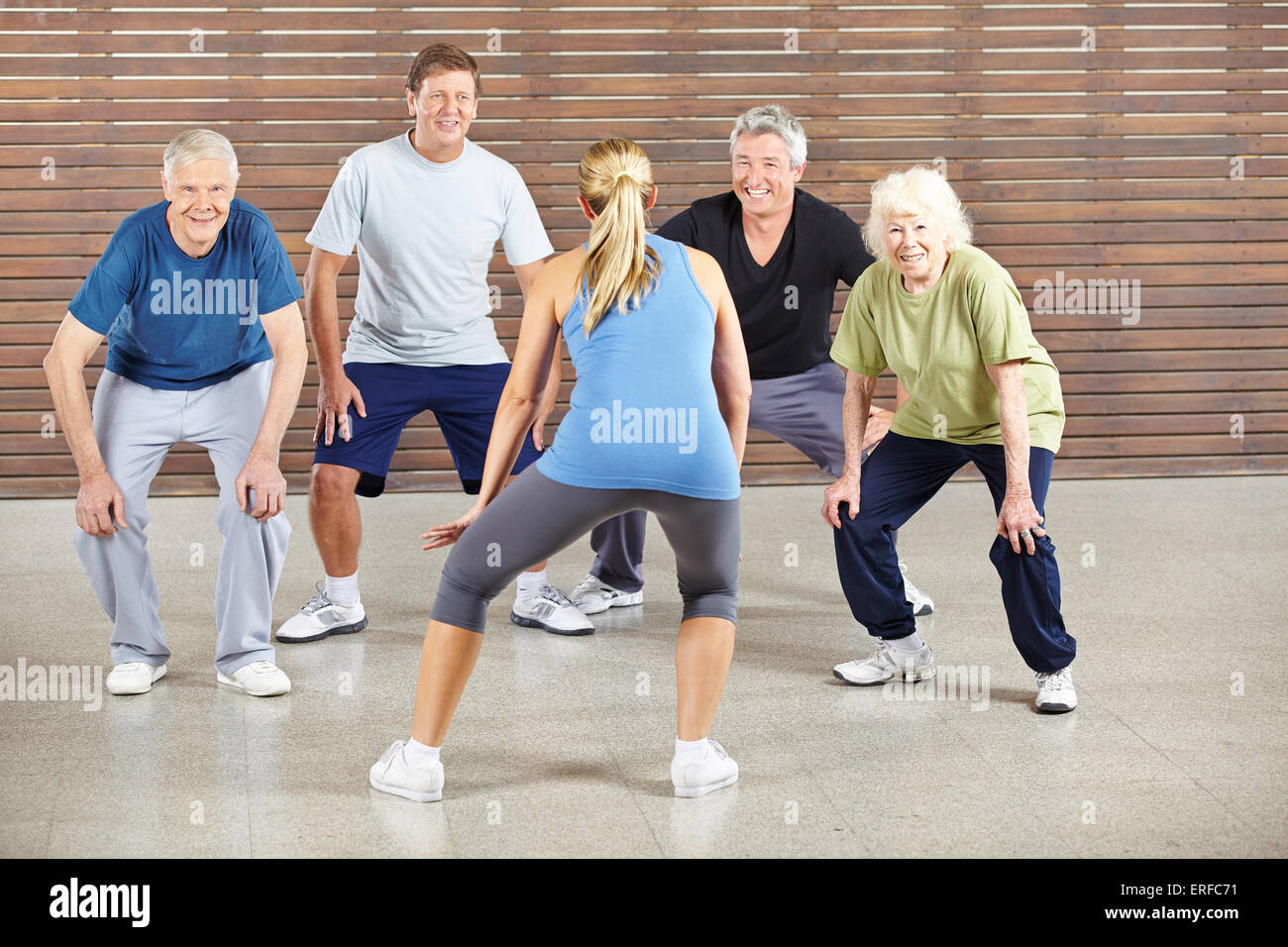 Senior people dancing to music in gym with dance instructor Stock Photo