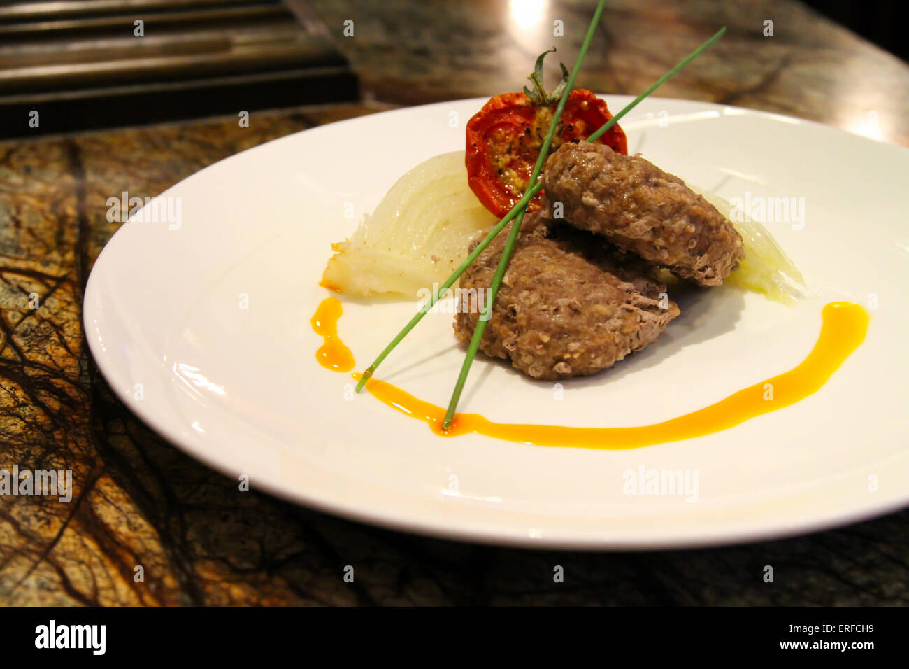 Delicious appetiser with some meat served in a white plate. Stock Photo