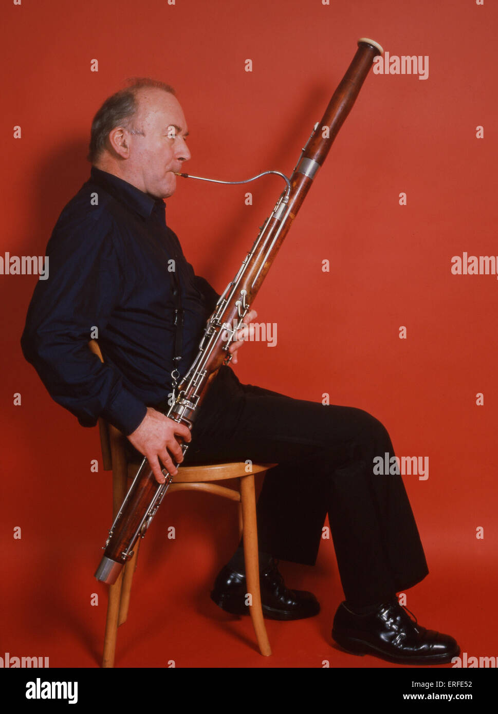 Bassoonist playing his bassoon Robert Codd Principal BBC National Orchestra of Wales. On a red