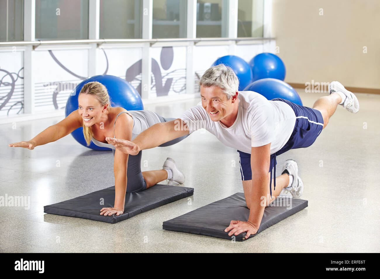 Man and woman doing gymnastics together in a fitness center Stock Photo ...