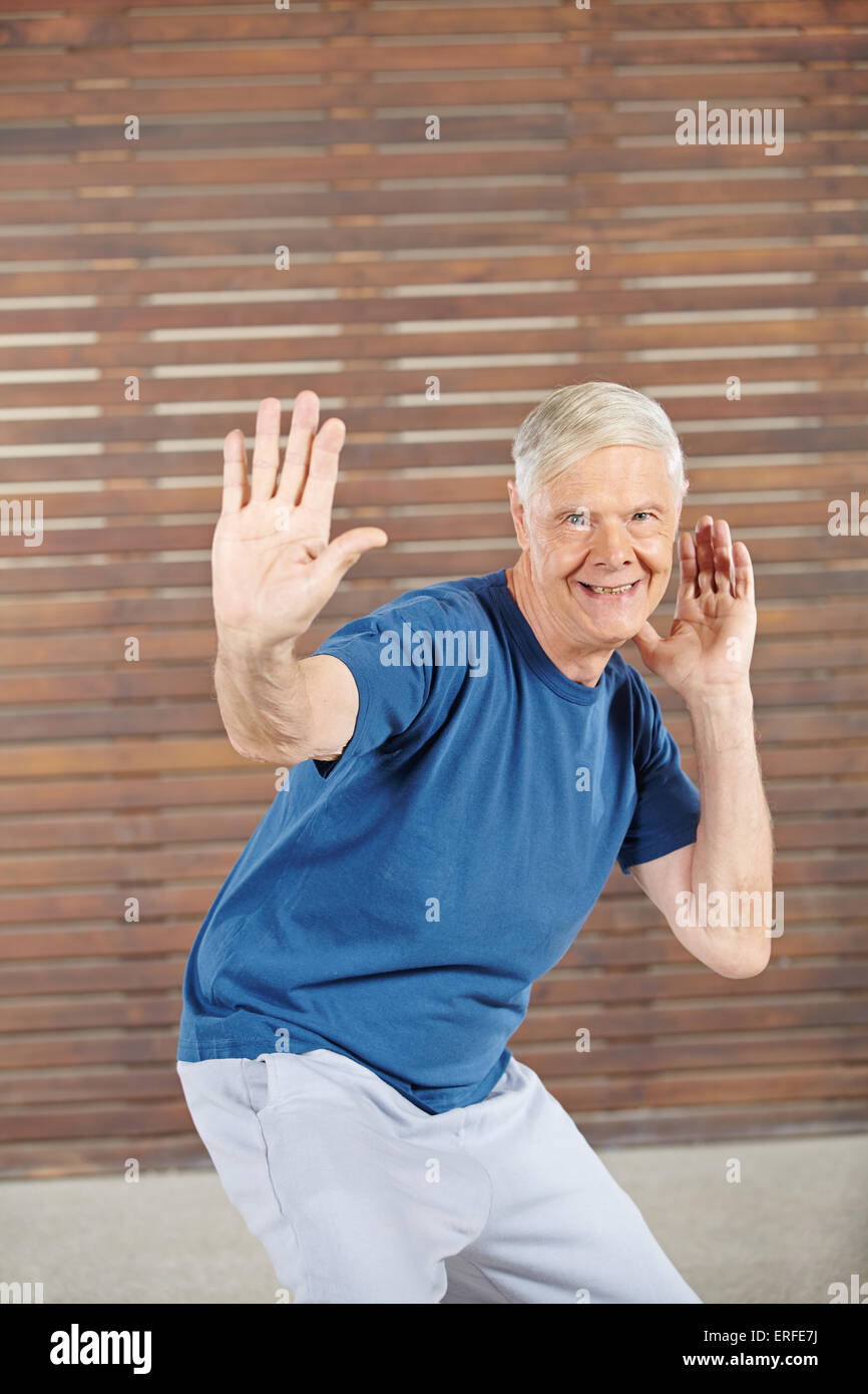 Old smiling man dancing in a fitness center Stock Photo