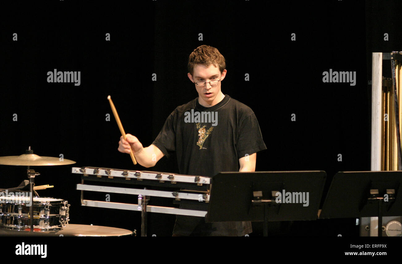 Young percussionist with multi percussion setup holding drum stick