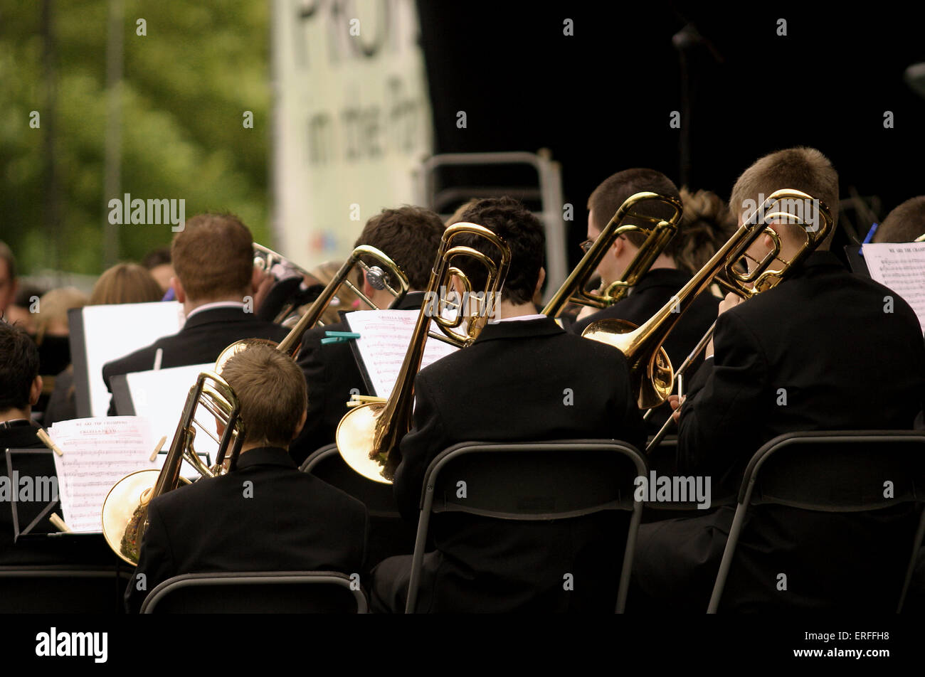 Trombones in Brass Band, Proms in the Park, Swansea. 2004 Back view of orchestra section Stock Photo