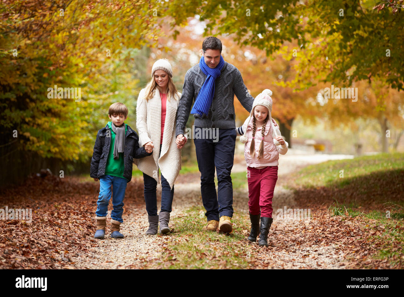 Family Walking Along Autumn Path Stock Photo