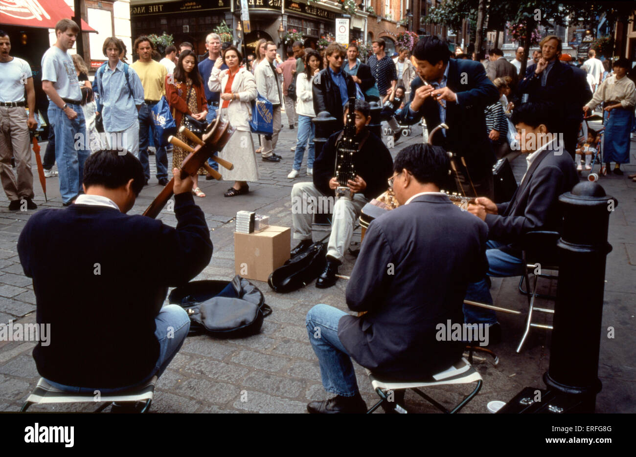 Chinese ensemble - musicians on the street, playing various Chinese instruments; (l-r:) Yueh-Chin (moon guitar); Erhu; Yangqin Stock Photo