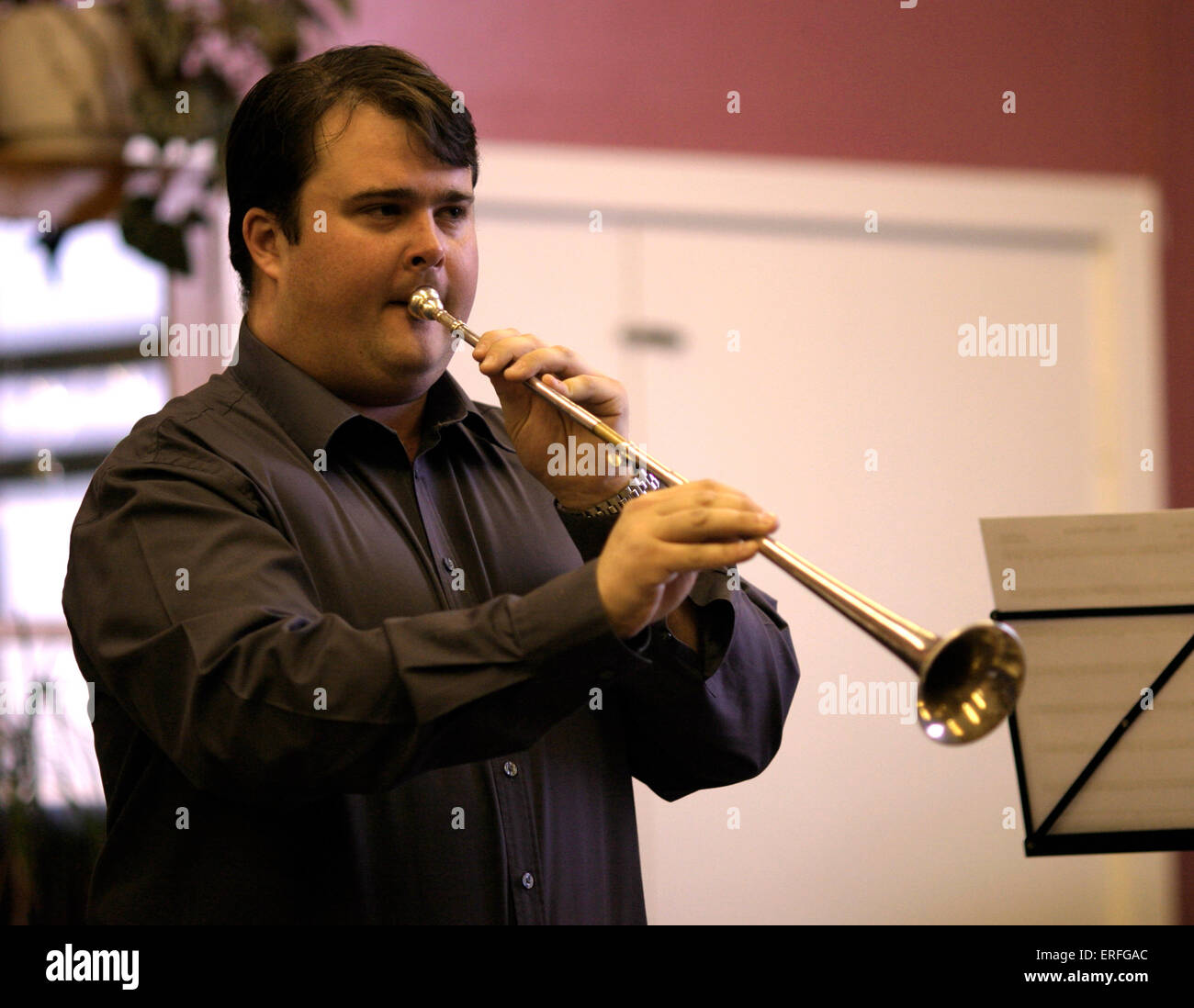 Post horn - being played by Simon Gray in a workshop posthorn. Stock Photo