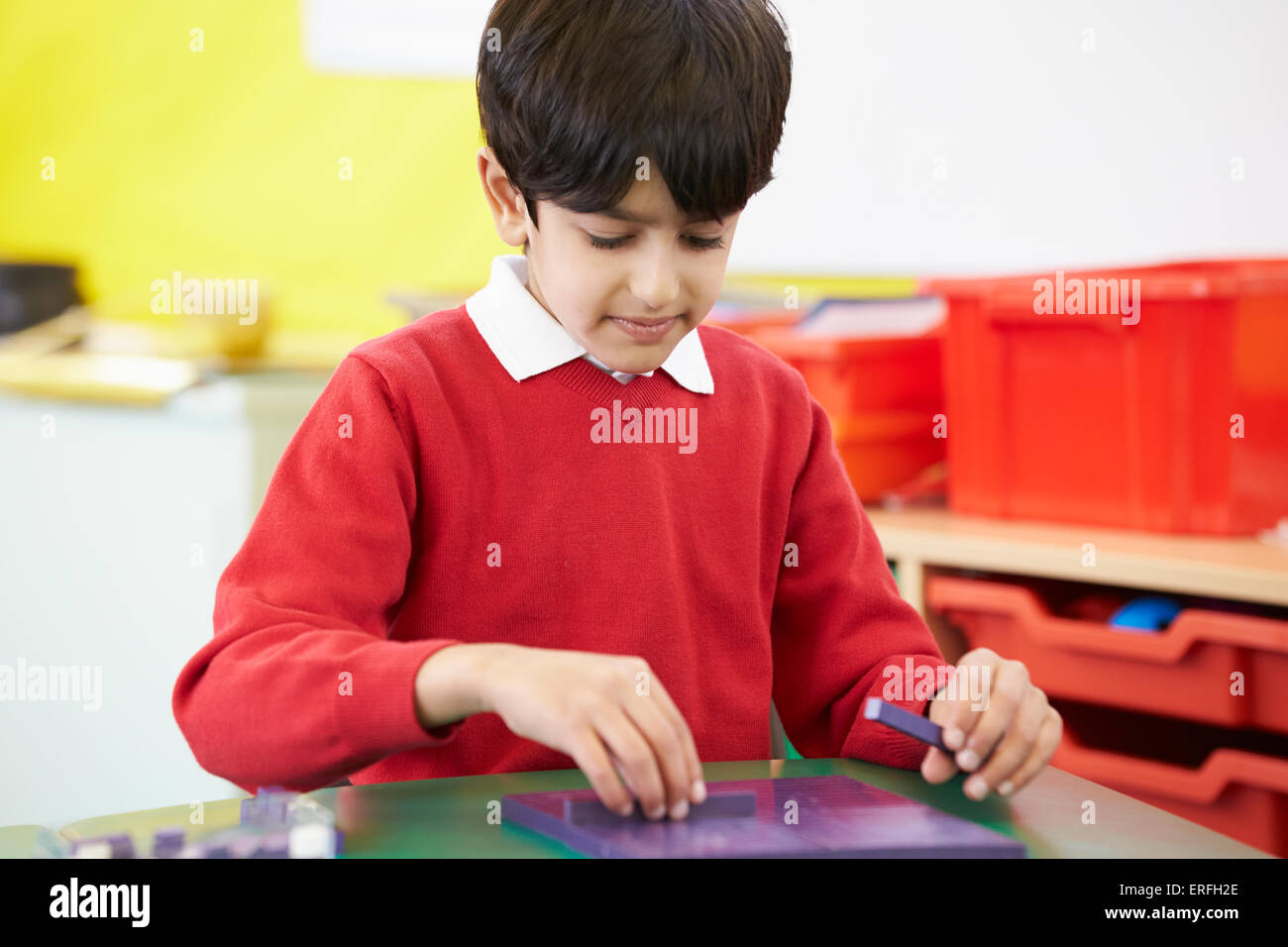 Male Pupil Practising Maths At Desk Stock Photo
