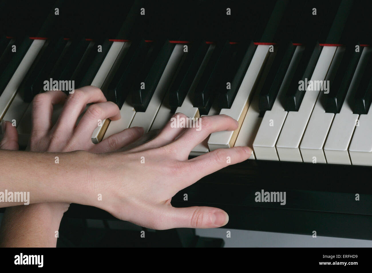 Piano - close-up of a female pianist 's hands crossing while playing. Stock Photo