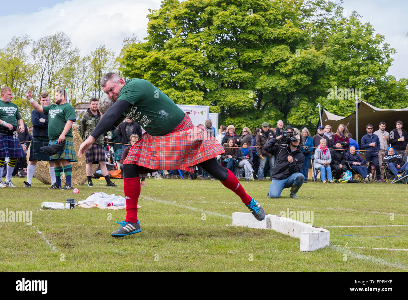 Competitor taking part in the 'stone Putt' competition at Carmunnock Highland Games, near Glasgow, Scotland, UK Stock Photo