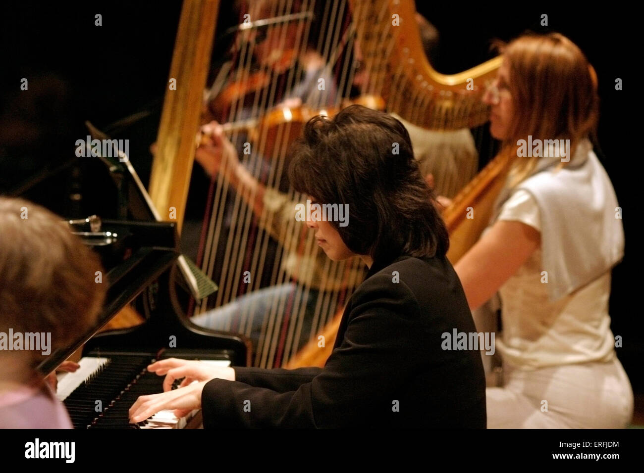 Noriko Ogawa - portrait of Japanese pianist playing the piano. Harpist in the background. Stock Photo