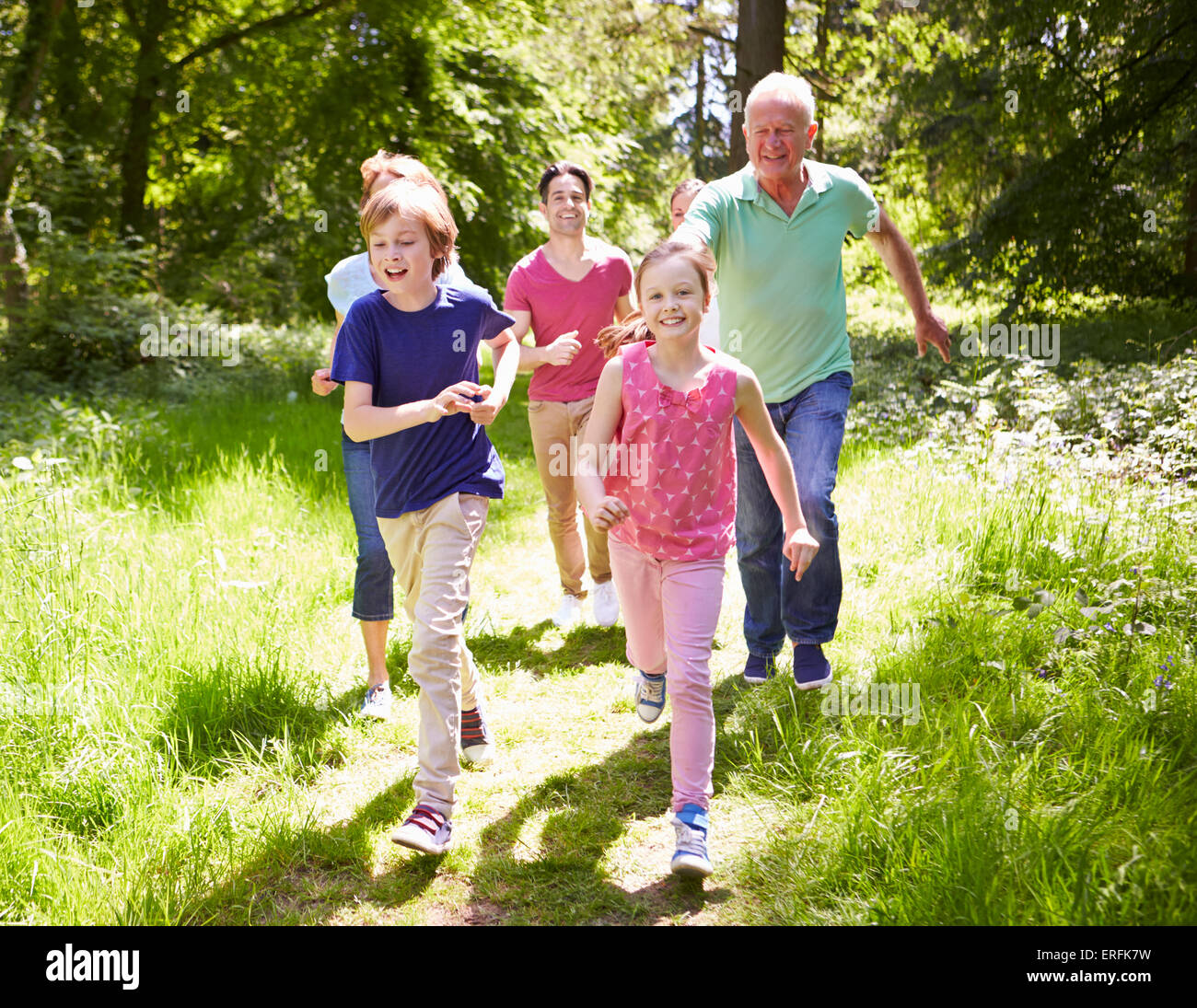 Multi Generation Family Running Through Summer Countryside Stock Photo