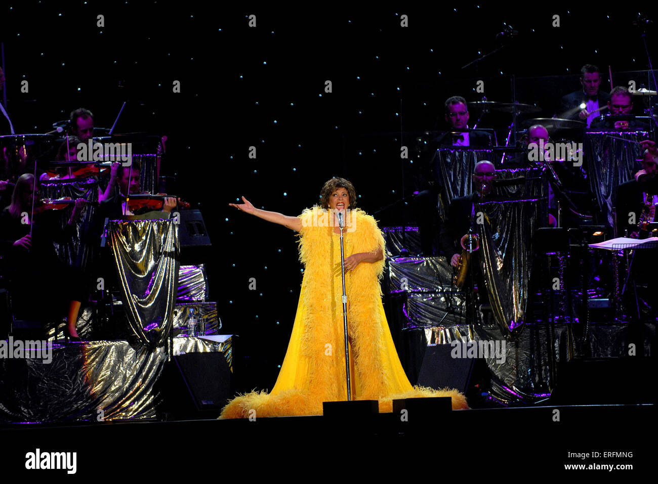 Shirley Bassey - Welsh singer performing at the Wembley Arena, London, UK, 9 June 2006. B. 8 January 1937, Dame Veronica Shirley Bassey. Wearing yellow dress. Gold decorations. Orchestra in the background. James Bond connection. Stock Photo