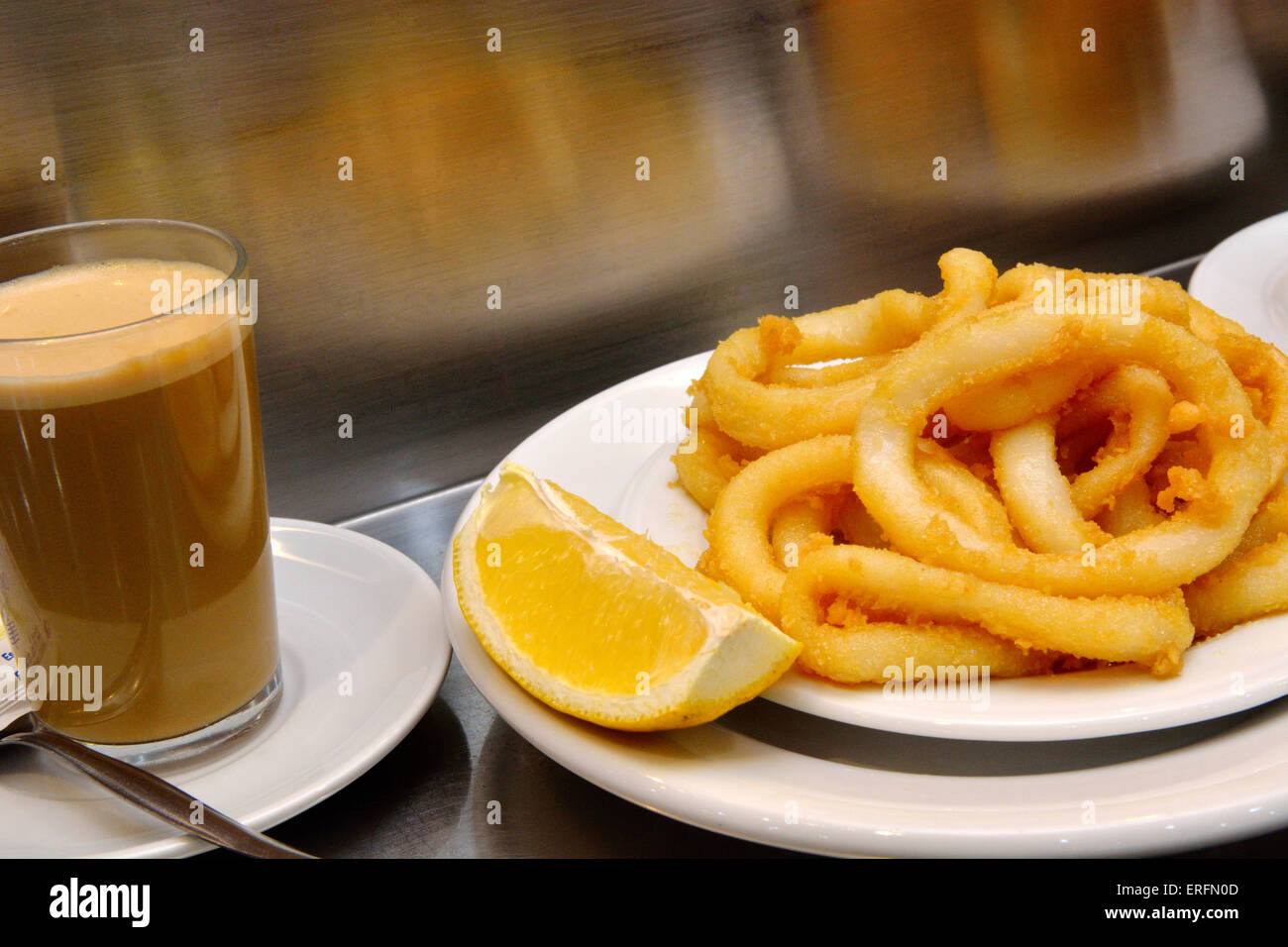 Plate of calamari with lemon and glass of coffee, Spain Stock Photo