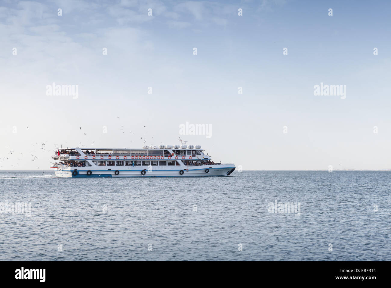 Izmir, Turkey - February 5, 2015: Big passenger boat full of people goes in Izmir bay, popular public city transport Stock Photo