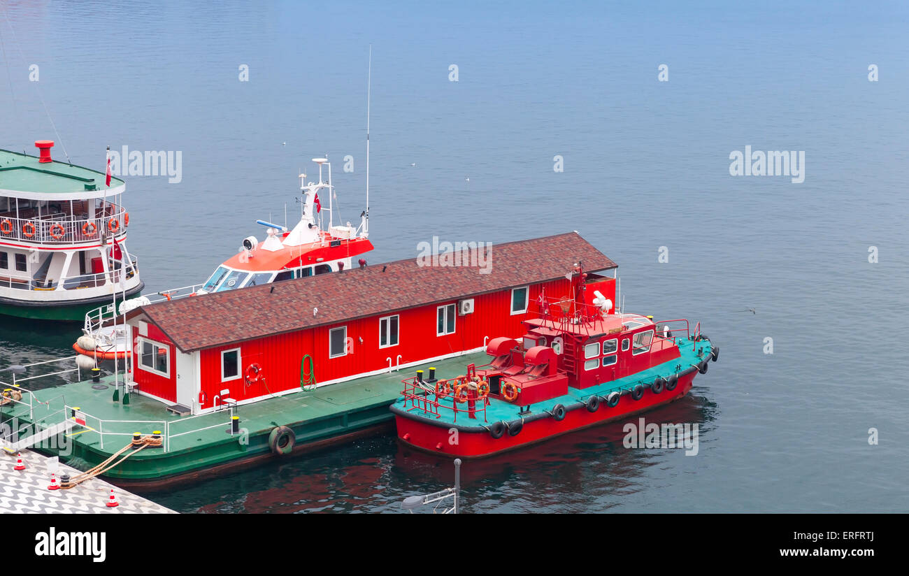 Red fire boat stand moored near floating fire station, Izmir, Turkey Stock Photo