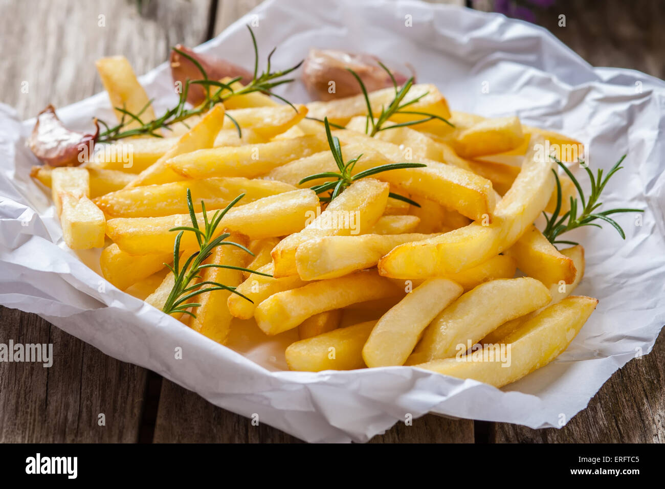 french fries with salt rosmery and garlic on white paper Stock Photo