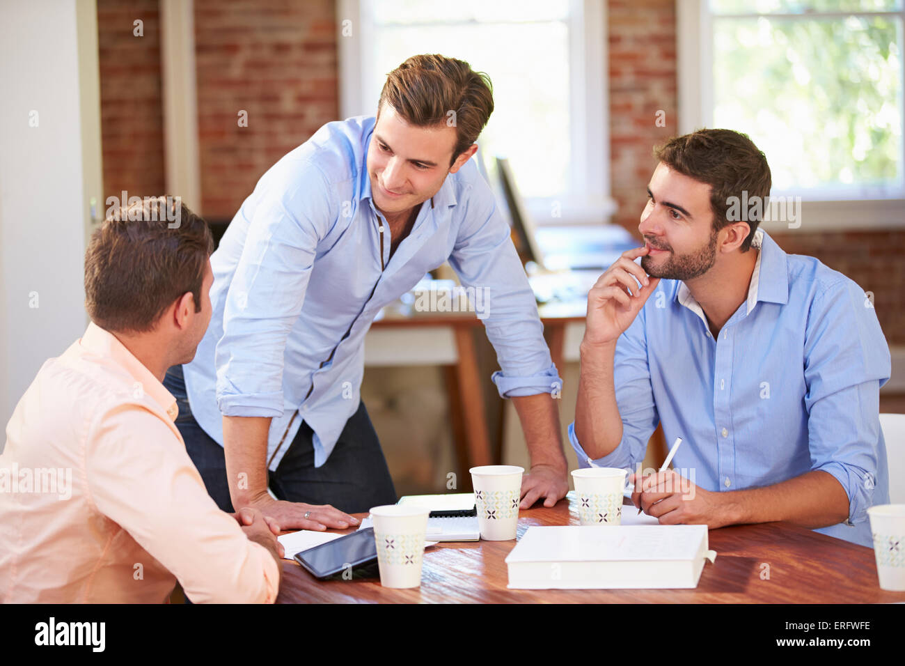Group Of Businessmen Meeting To Discuss Ideas Stock Photo