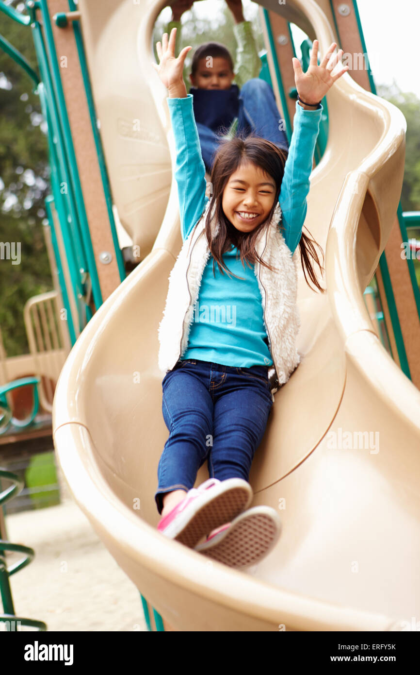 Young Girl Playing On Slide In Playground Stock Photo - Alamy
