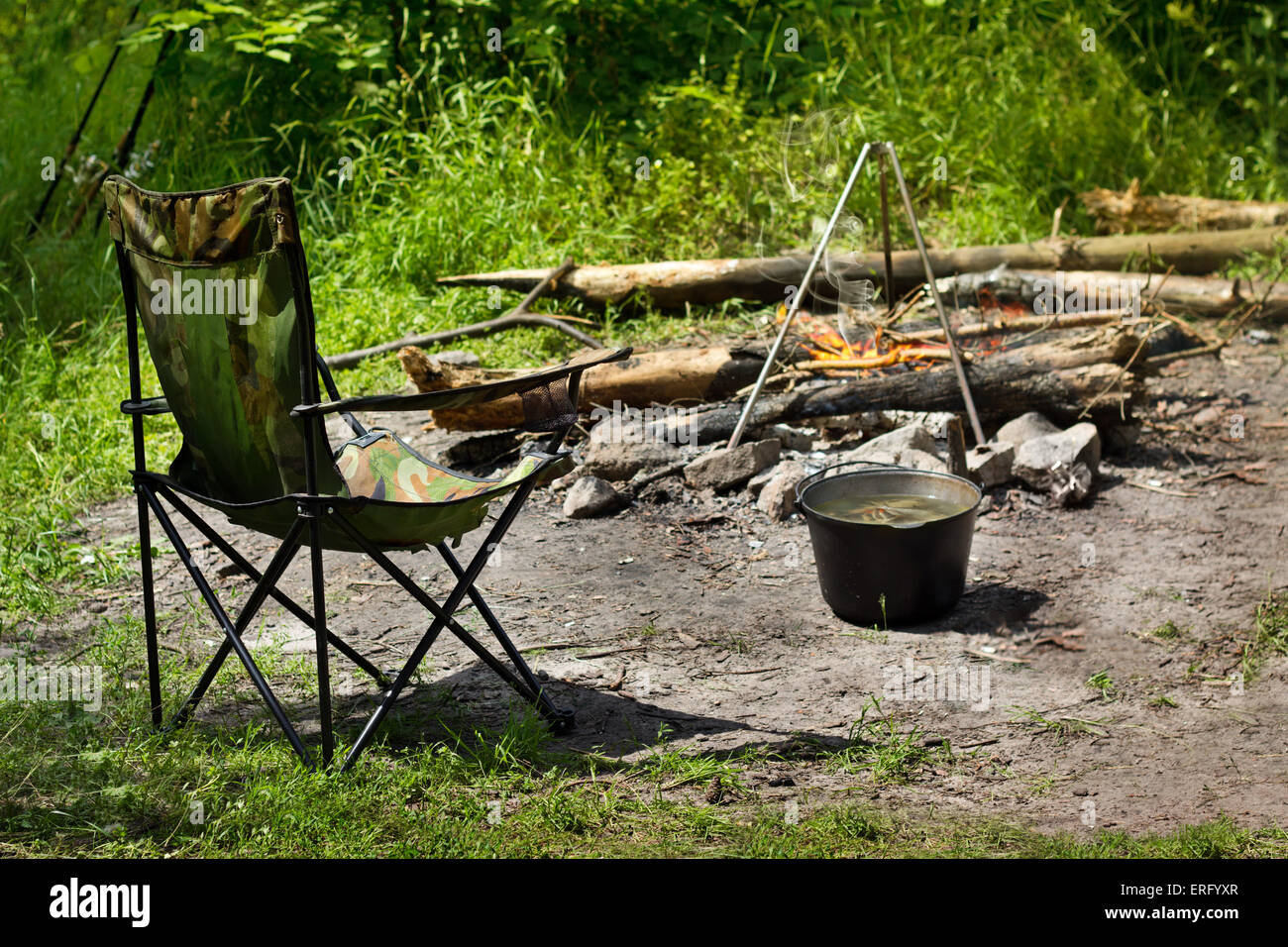 Relaxing and preparing food on campfire in camping, summer scene outdoors Stock Photo