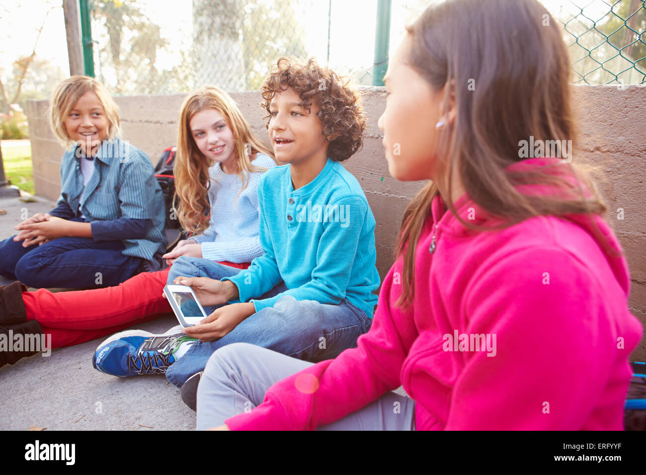 Group Of Young Children Hanging Out In Playground Stock Photo