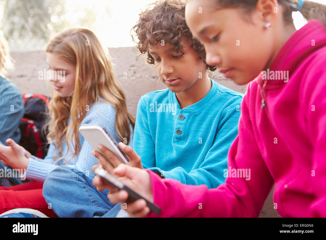 Group Of Young Children Hanging Out In Playground Stock Photo