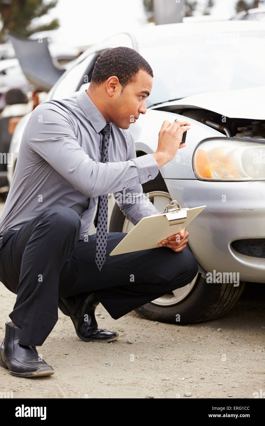Loss Adjuster Taking Photograph Of Damage To Car Stock Photo
