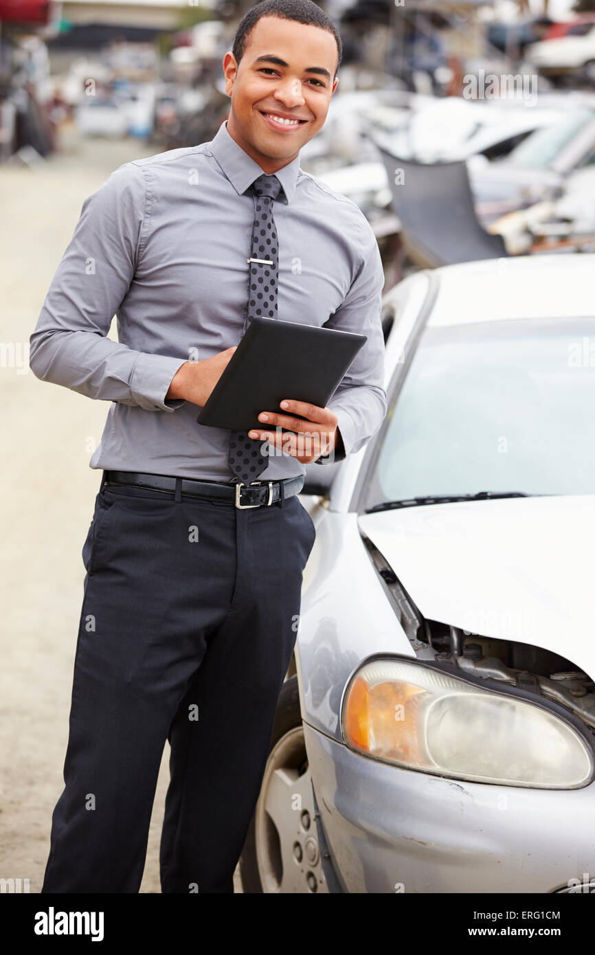 Loss Adjuster Using Digital Tablet In Car Wreck Inspection Stock Photo