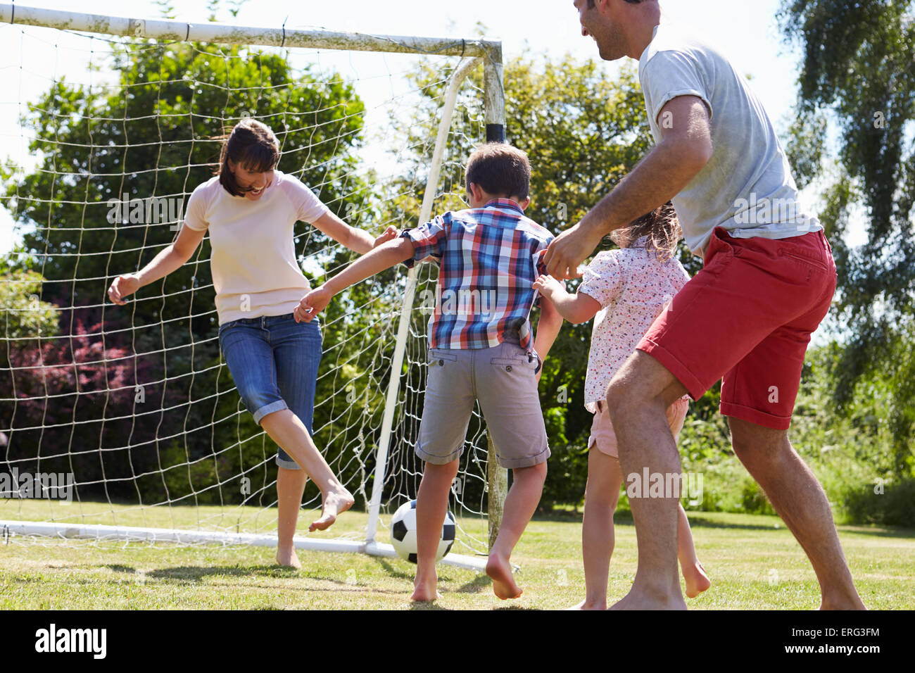 Family Playing Football In Garden Together Stock Photo - Alamy